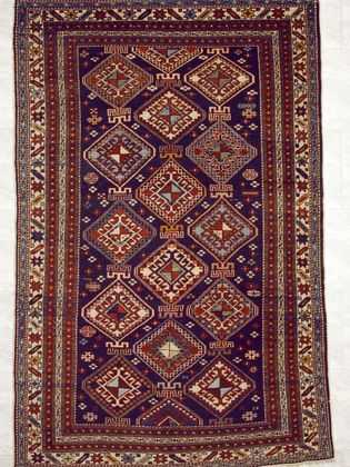 Tappeto shirvan antico con intricati dettagli decorativi geometrici rossi sul campo blu del tappeto e sullo spesso bordo bianco e blu